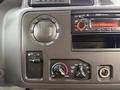 Dashboard controls of a 2009 Ford Econoline including climate control knobs and an audio system display