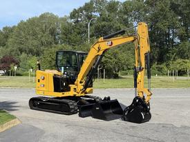 A yellow 2022 Caterpillar 306 excavator with tracks and a bucket attachment positioned on a concrete surface