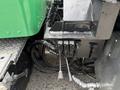 Close-up of hydraulic connections and levers on a 2013 Kenworth T370 truck with a green body and chrome accents