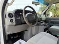 Interior view of a 2018 Ford E-450 with a steering wheel dashboard controls and gray fabric seating visible
