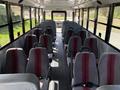 Interior of a 2011 Freightliner B2 school bus featuring rows of grey seats with red stripes and a central aisle