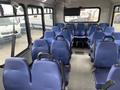 Interior of a 2020 Chevrolet Express shuttle bus featuring multiple rows of blue seats arranged in a spacious configuration
