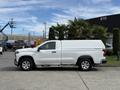 A white 2019 Chevrolet Silverado 1500 pickup truck with a covered bed is parked on a concrete surface