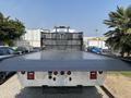 A 2020 Peterbilt 330 flatbed truck viewed from the rear with a metallic surface and lights at the top