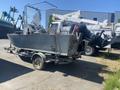 A 2010 aluminum 16-foot boat with an outboard motor mounted on the rear and a steering console at the front