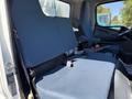 The interior of a 2015 Mitsubishi Fuso FE featuring two blue upholstered front seats with safety belts and armrests