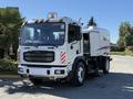 A 2012 Autocar XPERT truck designed for street cleaning with a large tank mounted on the rear and equipped with side brushes and a cab featuring visible lights and front grille