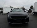 A black 2017 Dodge Charger is parked in the foreground with a sleek design and headlights visible, showcasing its sporty appearance and modern styling