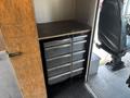 A dark metal tool drawer cabinet with multiple sliding drawers inside a vehicle compartment
