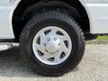 Close-up of a silver wheel and tire from a 2013 Ford Econoline featuring a rugged tread design and five-spoke wheel rim