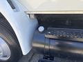 Close-up of a 2011 International 4300 truck showing a black fuel tank with a cap and part of the white bodywork adjacent to it