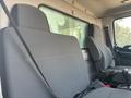 Interior view of a 2012 Hino 338 cabin showing two gray seats with safety belts and a central console