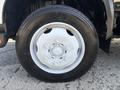 Close-up of a white wheel and tire from a 2018 Hino 195 showcasing a six-bolt pattern and a rugged tread design