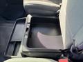 A storage compartment between the front seats of a 2014 RAM 5500 with a textured surface and a lid that can be opened for access to the storage space inside