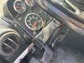 Close-up of a 2011 Autocar Xpeditor's steering column showing a black stalk for headlights and dashboard gauges displaying speed and fuel levels