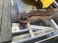 A close-up view of a rusted and corroded section of a metal trailer with yellow paint showing deterioration and exposed metal on the surface