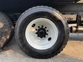 Close-up of a black tire with a white wheel on a 2016 Freightliner M2 106 showcasing the tire tread pattern and lug nut configuration