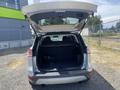 A 2015 Ford Escape with its rear hatch open revealing a spacious cargo area and dark upholstery inside
