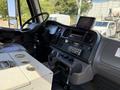 Interior of a 2010 Freightliner M2 106 truck featuring a dashboard with various controls and a digital display console