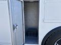 A 2005 Freightliner M2 106 with an open side door revealing an empty compartment and an unlit interior