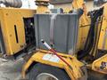 A 2015 Vermeer Corporation BC1200XL wood chipper featuring a large gray fuel tank secured with a strap and a red-handled control lever on the side