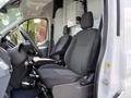Interior view of a 2018 Ford Transit showing the driver's seat and passenger seat with gray upholstery and a steering wheel visible