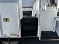 A set of metal steps leading up to the cab of a 2013 International 7500 with a textured surface for grip and adjacent control panels visible