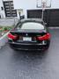 A black 2016 BMW 4-Series Gran Coupe parked with the rear view visible showcasing its sleek design and distinctive tail lights