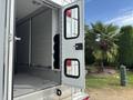 A 1994 GMC Vandura 3500 van with open rear doors revealing a spacious interior with metal flooring and shelves