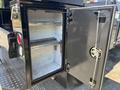A 2022 Ford F-350 SD with an open tool compartment featuring a metal shelf and a secure locking mechanism