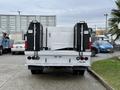 A 2016 Ford F-550 Super Duty truck with a white body and black toolboxes on either side of the flatbed