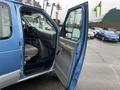 A blue 2006 Ford Econoline van with an open front door revealing the interior and driver's seat