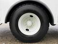 A close-up of a tire and wheel from a 2005 Freightliner M2 106 featuring a white rim with a central hub and a thick black tire with visible tread patterns