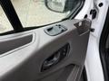 Close-up view of the interior door panel of a 2020 Ford Transit featuring window controls and a handle