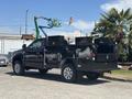 A black 2022 Ford F-350 SD truck with storage compartments in the bed and chrome wheels parked in an outdoor setting