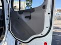 The interior door panel of a 2011 Freightliner M2 106 featuring a gray finish with a handle and a textured surface