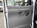 A close-up of the driver's side door interior of a 2008 Ford Econoline featuring a gray panel with a door handle and window crank