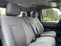 Interior of a 2013 Ford F-250 SD featuring gray cloth seats with a bench configuration and seatbelts across the front row