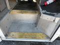 A set of steps leading up into a 2012 Ford Econoline with a textured metal surface and yellow safety markings