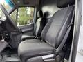 Interior view of a 2012 Mercedes-Benz Sprinter showing driver and passenger seats with black fabric and a textured pattern