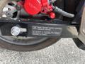 2018 Honda Grom with a visible spark ignition system label and red brake caliper close-up