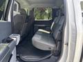 Interior view of a 2021 Ford F-150 showing the rear seating area with gray upholstery and a flat floor design