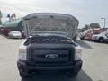 A 2014 Ford F-250 SD with the hood raised revealing the engine compartment