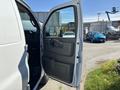 A 2019 GMC Savana van with an open side door showcasing the interior door panel and handle