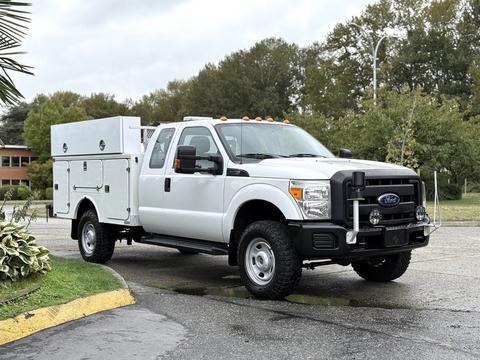 A 2015 Ford F-350 SD truck with an extended cab and a service body featuring compartments for tools and equipment