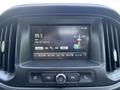 Dashboard of a 2017 Chevrolet Colorado featuring a touchscreen display showing radio station information and song title