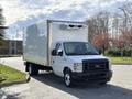 A 2023 Ford E-450 box truck with a white body and a front grille featuring a black bar design