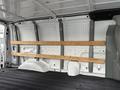 A white 2006 Ford Econoline van interior with wooden support beams secured to the walls and a flat floor without any cargo or additional features visible