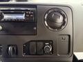 Dashboard of a 2014 Ford Econoline featuring a radio display and controls for temperature and other settings