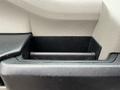 A storage compartment in a 2018 Ford F-150's interior with a textured plastic surface and a cylindrical holder